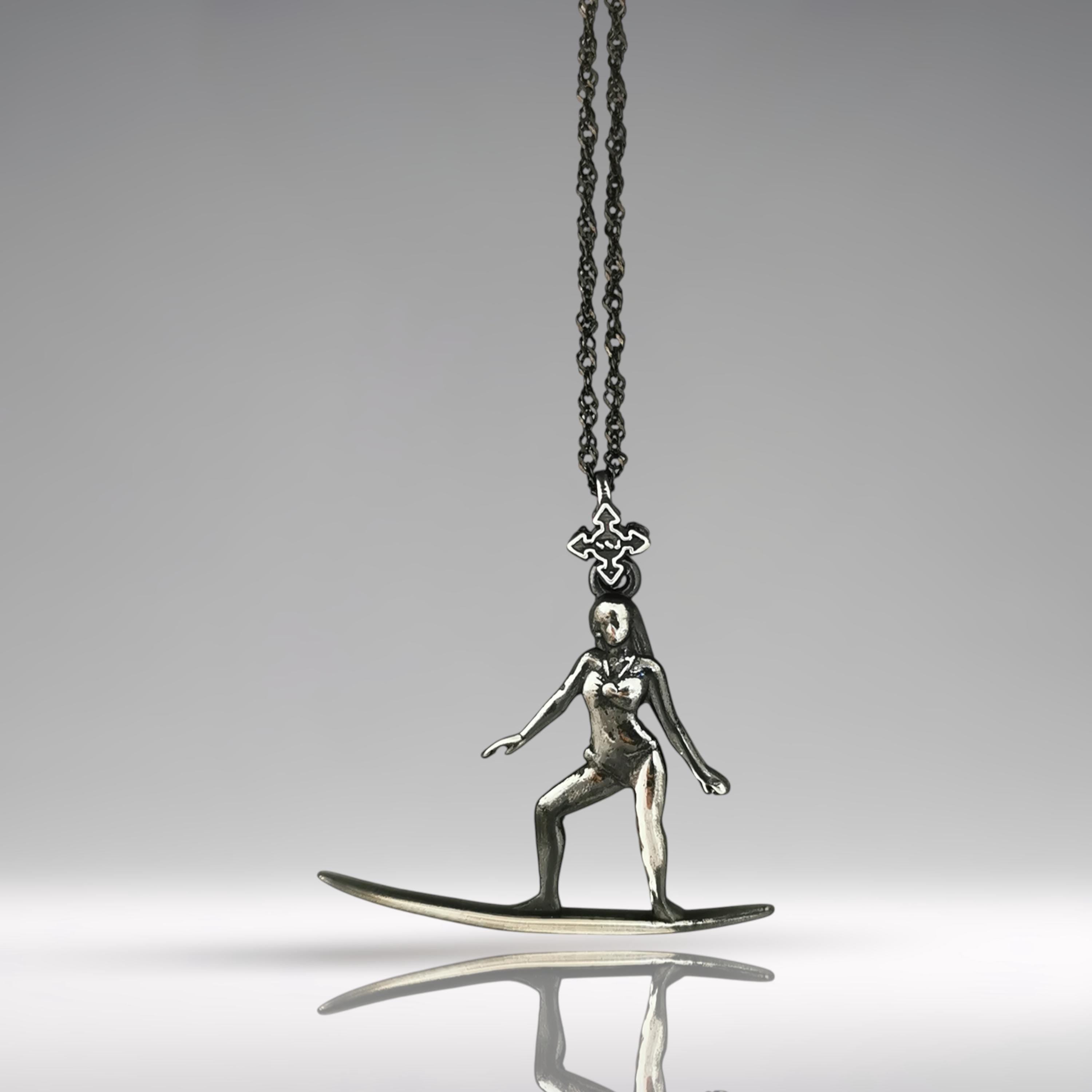 Vintage-style surf girl necklace handcrafted in patinated 925 sterling silver — a soulful pendant capturing the elegance and ease of classic surf culture.
This nostalgic piece features a female surfer mid-ride, her form confident and fluid. The aged silver finish brings retro charm and timeless spirit, making this necklace ideal for women who are connected to the ocean, grounded in movement, and guided by freedom. A wearable story of waves, wind, and wild hearts.