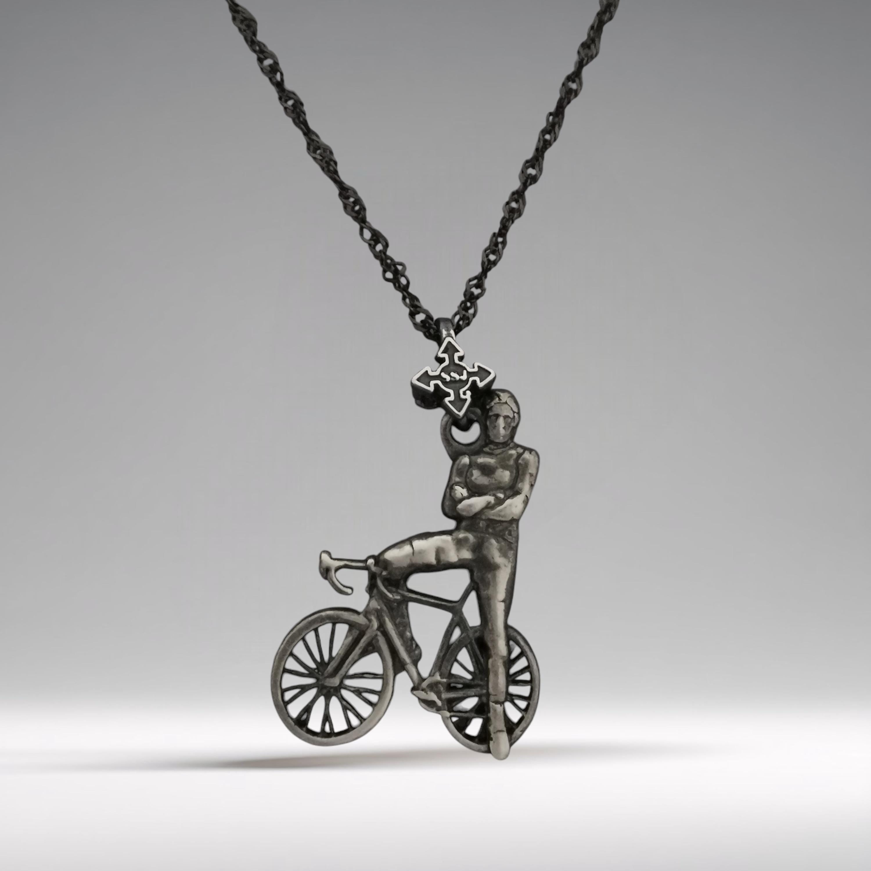 Vintage-style cyclist necklace handcrafted from solid 925 sterling silver — a striking pendant portraying the strength and calm confidence of a modern-day rider.
The design features a male cyclist leaning casually against his bicycle, arms crossed with pride — an emblem of dedication, control, and athletic identity. Finished in a soft vintage patina, this piece carries nostalgic energy and timeless masculinity.