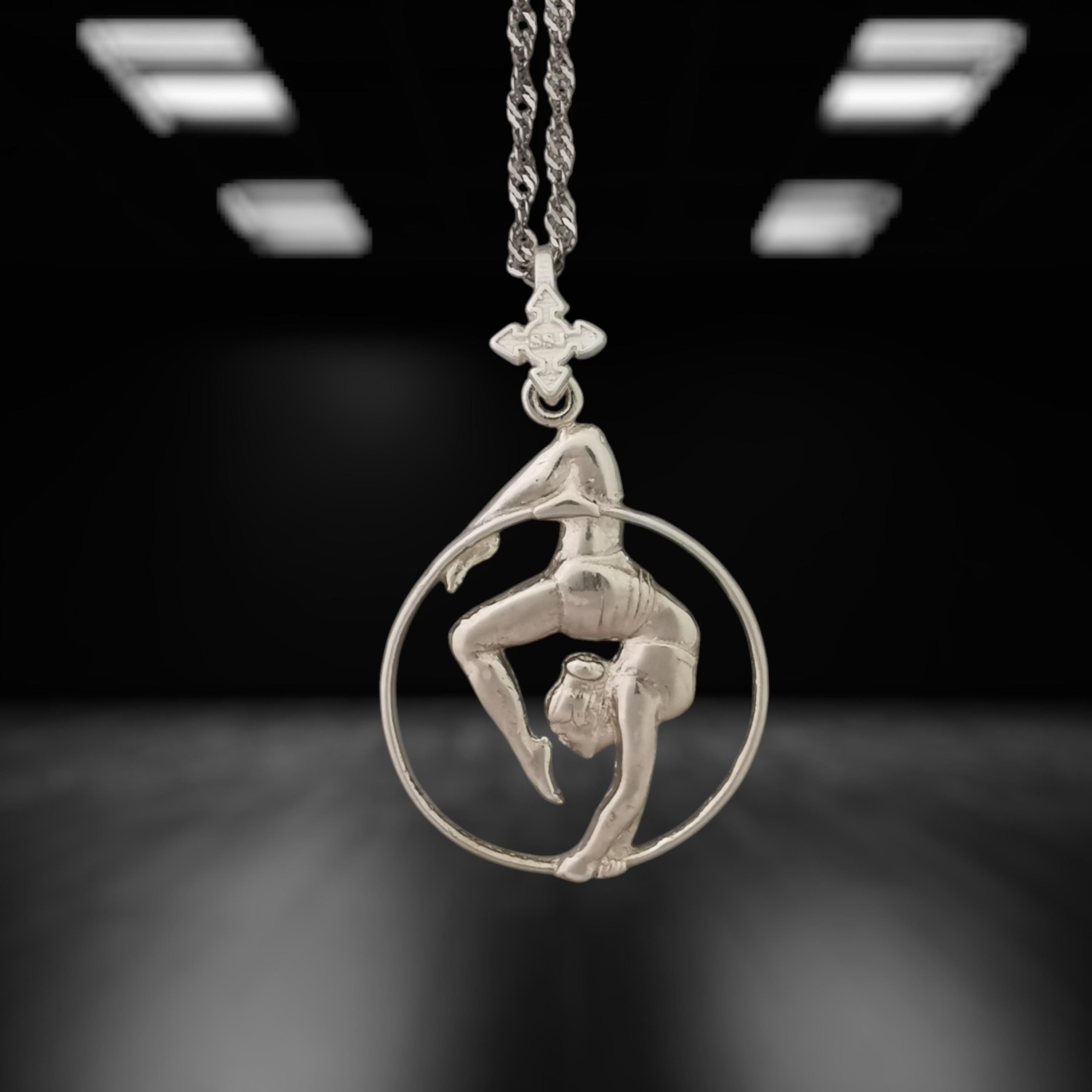 Classic aerial hoop necklace handcrafted from solid 925 sterling silver — a delicate and striking pendant that honors the elegance of aerial performance and the beauty of the human form in motion.
The design features a female aerialist suspended mid-flow, captured in an expressive pose that radiates balance, flexibility, and femininity. A meaningful piece for those drawn to dance, circus art, or the poetic lines of aerial movement. Wearable art with strength and grace.