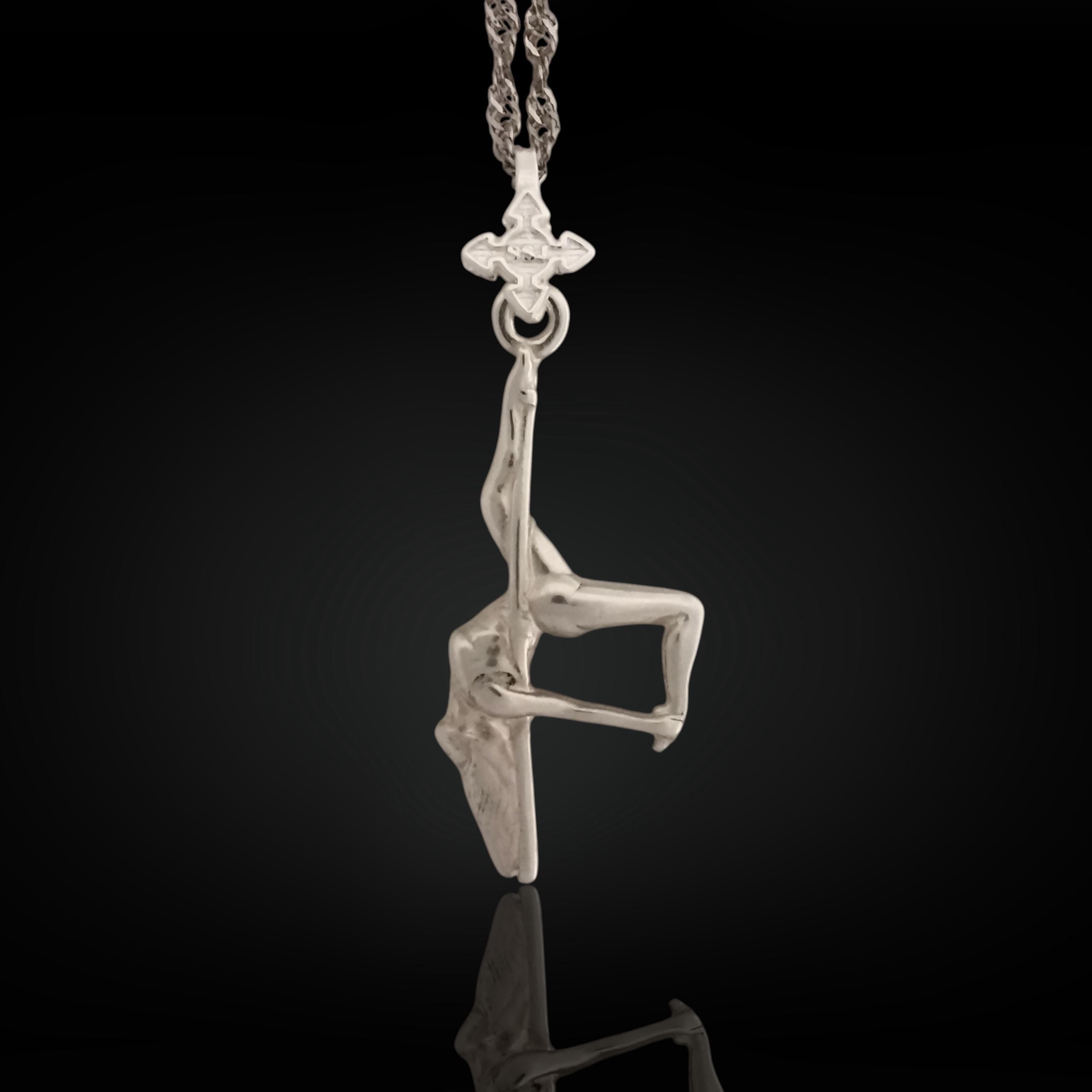 Pole dance pendant handcrafted in solid 925 sterling silver – a radiant and artistic tribute to feminine beauty, strength, and fluid movement.
This sculptural piece captures a pole dancer mid-performance, posed in a dramatic inverted position with expressive detail. The polished silver enhances the flowing curves and emotional intensity of the figure, turning motion into wearable art. A statement of confidence, seduction, and unapologetic expression.